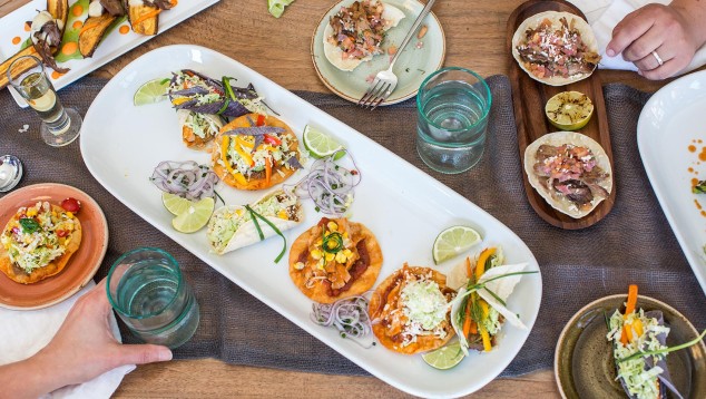 People eating food around a table at Cocoloba Cayman